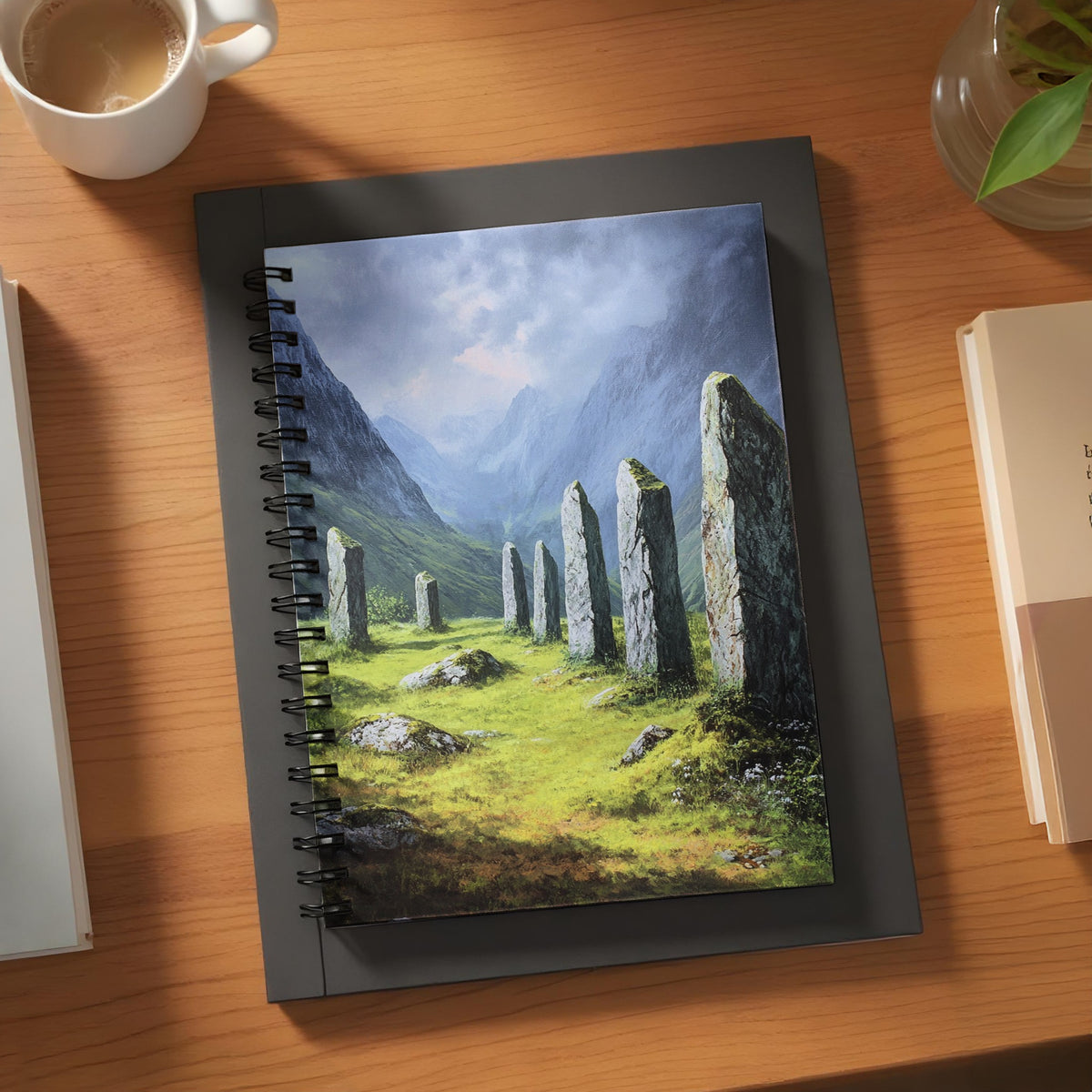 Spiral notebook featuring a painting of a standing stone circle in a green valley.