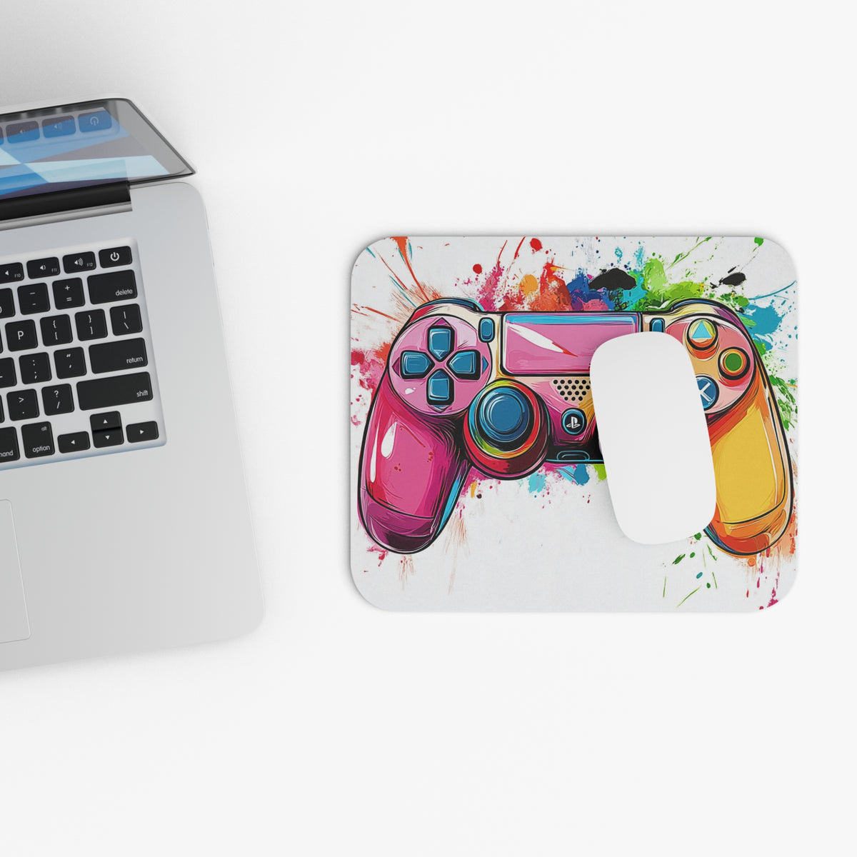 Mousepad with colorful splatter art and a pink gaming controller design.