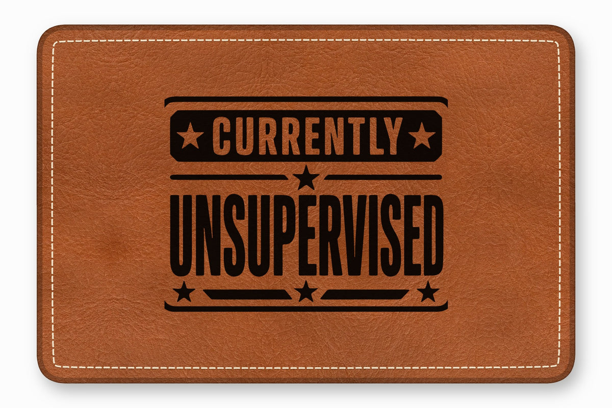 Brown leather patch with white stitched border and the black text Currently Unsupervised.