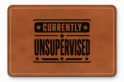 Brown leather patch with white stitched border and the black text Currently Unsupervised.