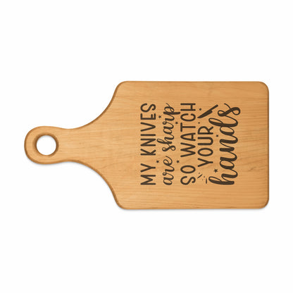 Wooden cutting board with the engraved text "MY KNIVES are sharp SO WATCH YOUR hands".