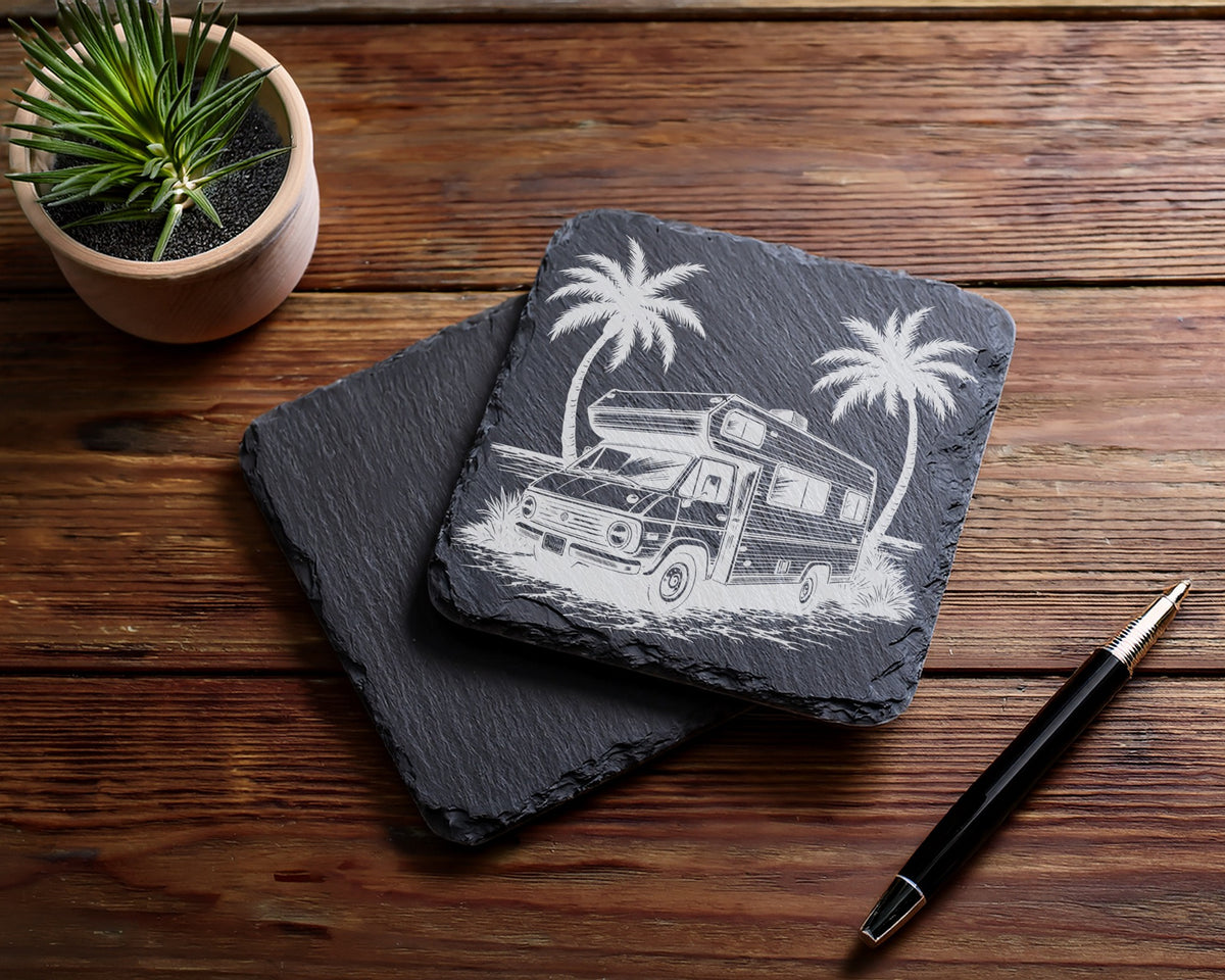 Slate coaster with etched vintage RV and palm trees, beside a plant and pen.