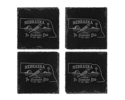Four Nebraska state outline coasters with farm scene and text.