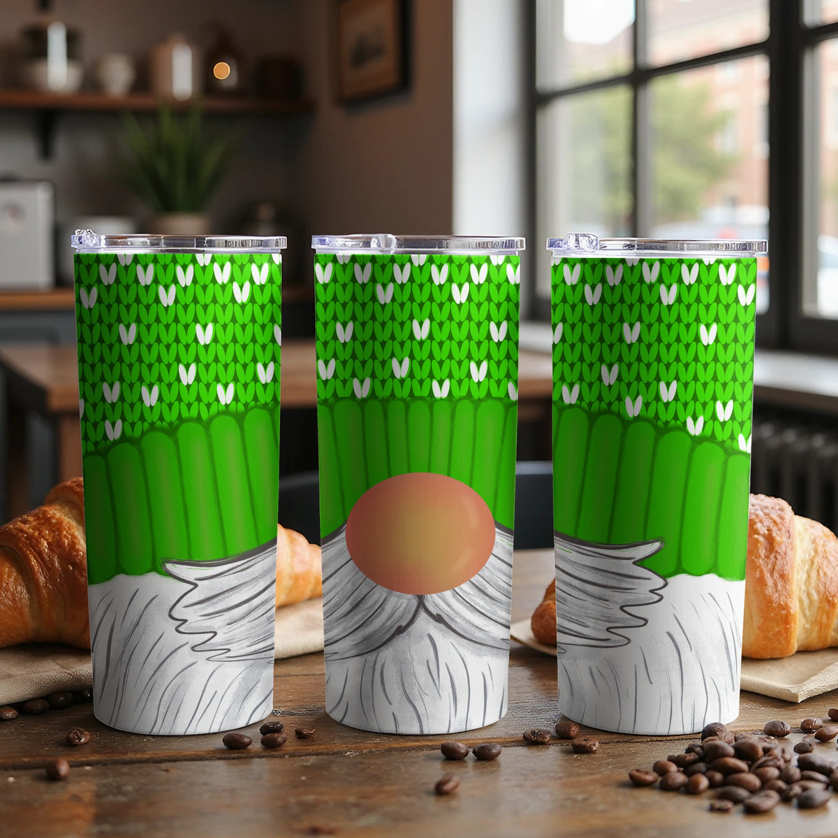 Green gnome tumbler with white knit pattern and red nose, set on a table.