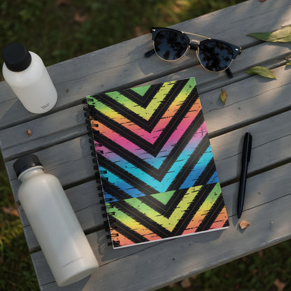 Notebook with rainbow chevron pattern on black background, two water bottles, and sunglasses.