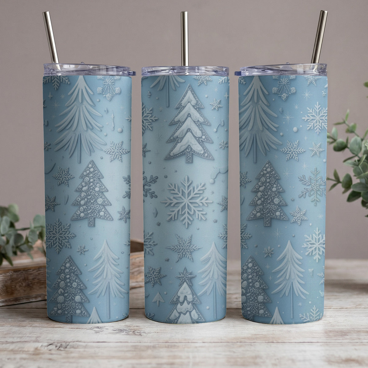 Three light blue tumblers with a festive embossed pattern of Christmas trees and snowflakes.
