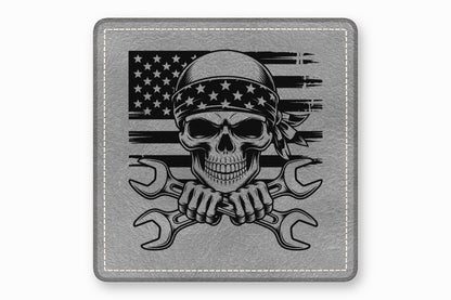 Gray leather patch featuring a skull wearing a star-patterned bandana over a distressed American flag with crossed wrenches.