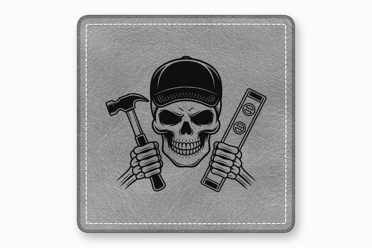 Square grey leather patch featuring a black illustration of a skull in a baseball cap holding a hammer and a level.