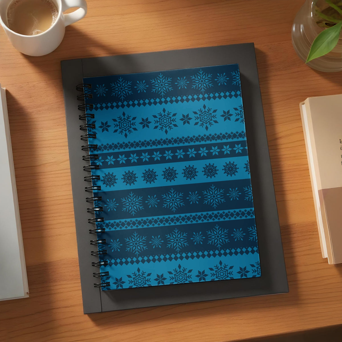 Spiral bound notebook with dark blue and light blue snowflake and geometric patterns.