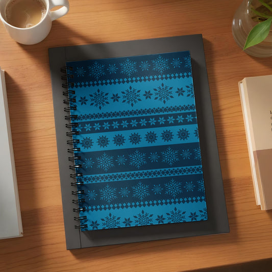 Spiral bound notebook with dark blue and light blue snowflake and geometric patterns.