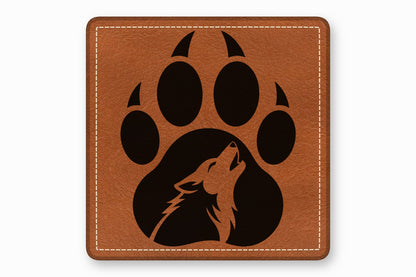 A square brown leather patch with white stitching featuring a black paw print enclosing a howling wolf silhouette.