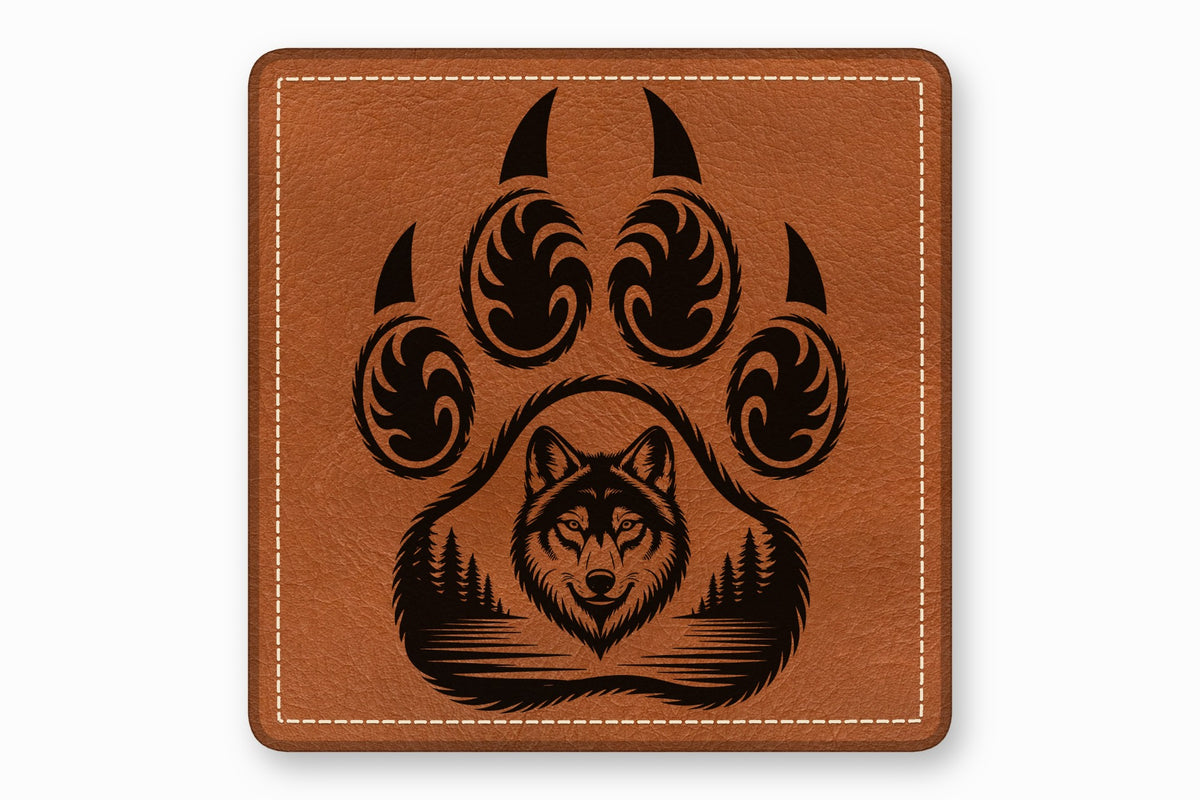 Square brown leather patch with white stitching featuring a black paw print enclosing a wolf head and forest landscape.