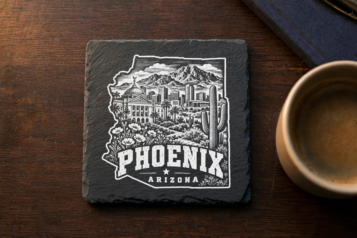 A square slate coaster engraved with a detailed Phoenix, Arizona skyline and desert landscape illustration.