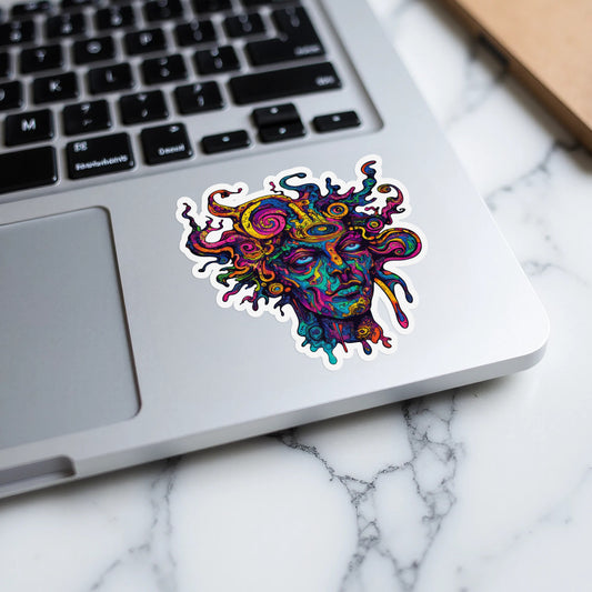 Colorful abstract sticker of a face with snake-like hair on a laptop.