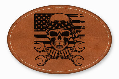 Oval brown leather patch featuring a skull in a bandana and crossed wrenches over an American flag.