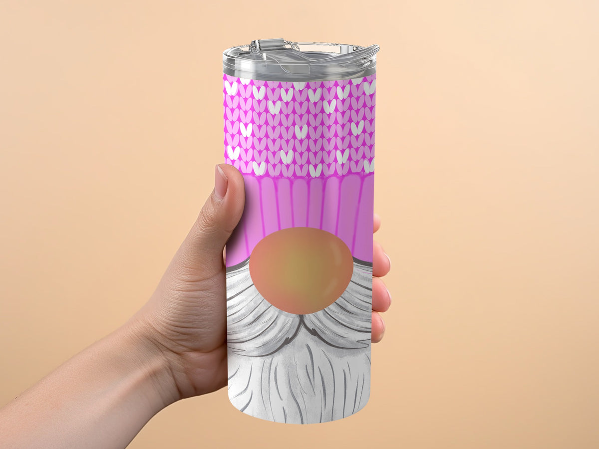 Tumbler with pink knit pattern and gnome design held by a hand.
