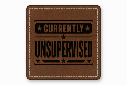 Brown leather patch with white stitched border and black text reading Currently Unsupervised.