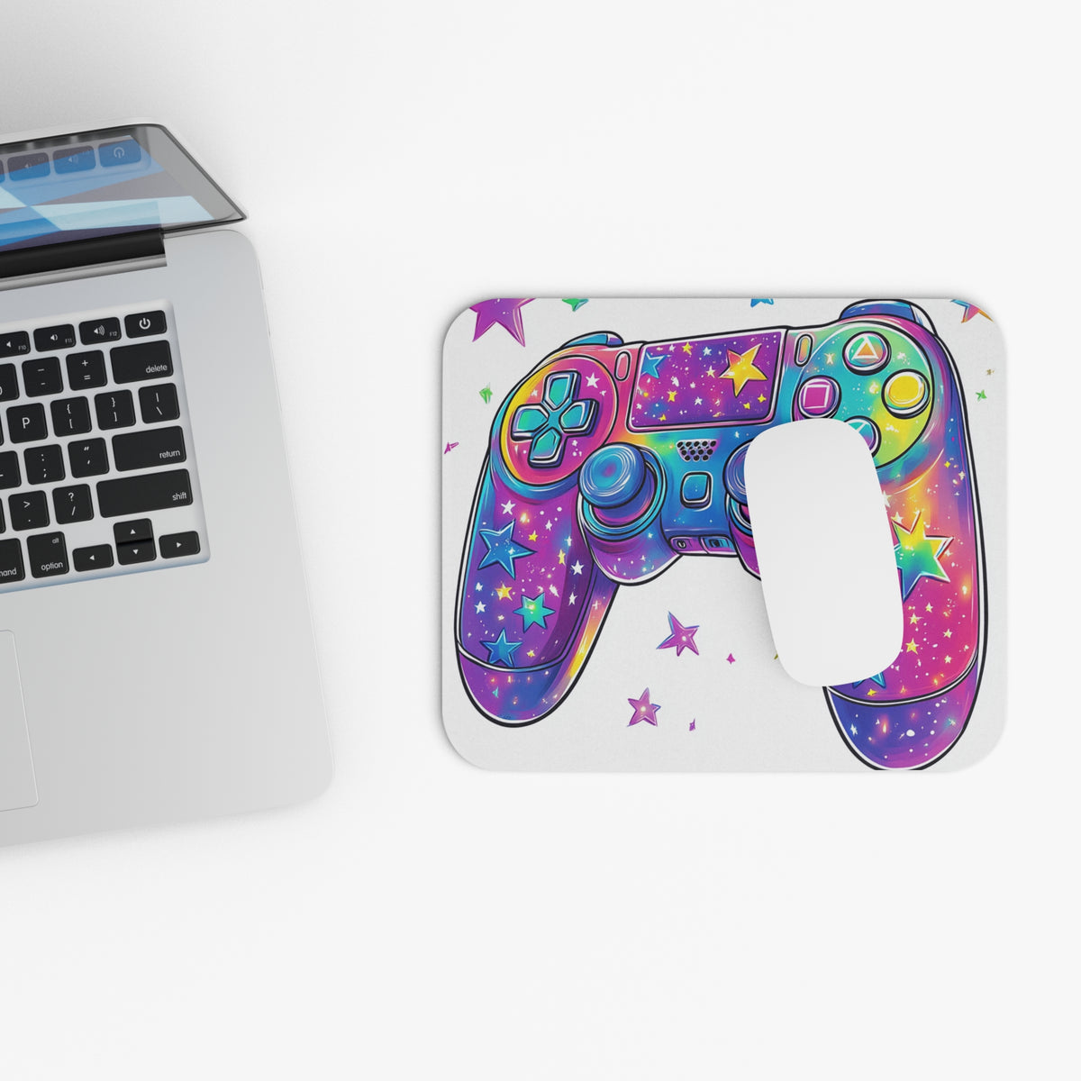 Colorful star-patterned gaming controller on a mousepad next to a laptop.