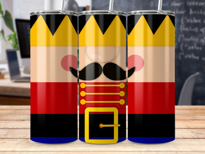 Three stainless steel tumblers wrapped with a cartoon nutcracker design, featuring a gold crown and mustache.