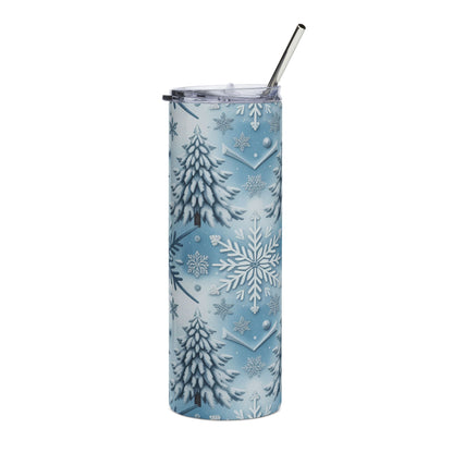 Blue tumbler with snow-covered trees and snowflakes pattern, with a metal straw.