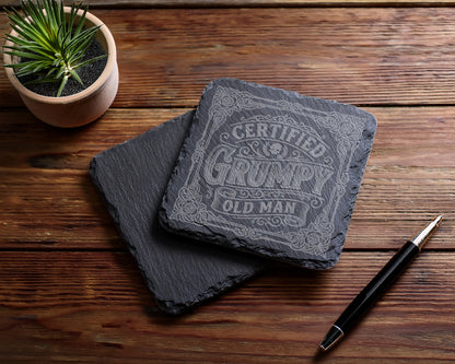Slate coaster engraved with "Certified Grumpy Old Man" text and decorative border.