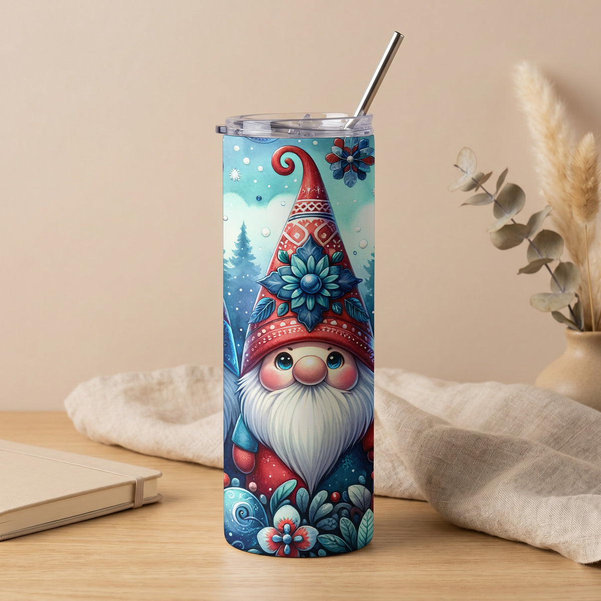 Tall tumbler with a cute gnome wearing a red hat, a winter scene, and a metal straw.