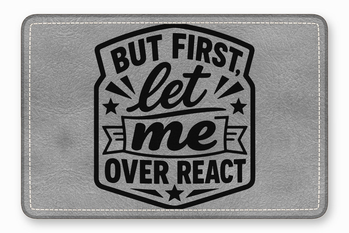 Grey leatherette patch with white stitched borders and black text that reads But First, let me OVER REACT.