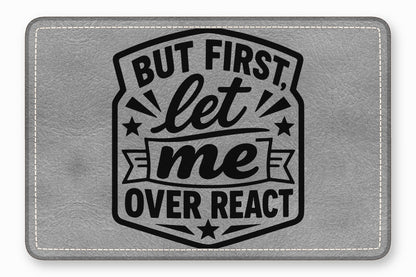Grey leatherette patch with white stitched borders and black text that reads But First, let me OVER REACT.