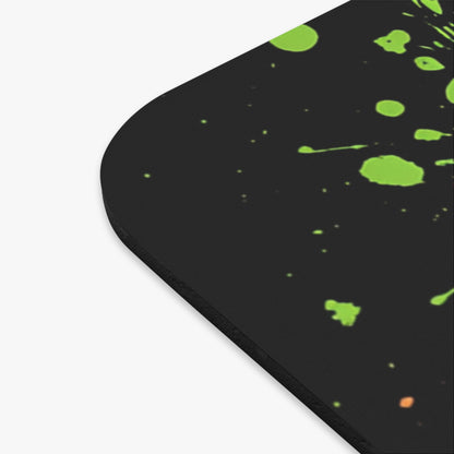 Black mousepad with green and orange paint splatters.
