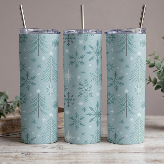 Three tumblers with a light blue, snowflake, and Christmas tree pattern, each with a silver straw.