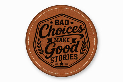 A round brown leather coaster with white stitched edges features the black text Bad Choices Make Good Stories.