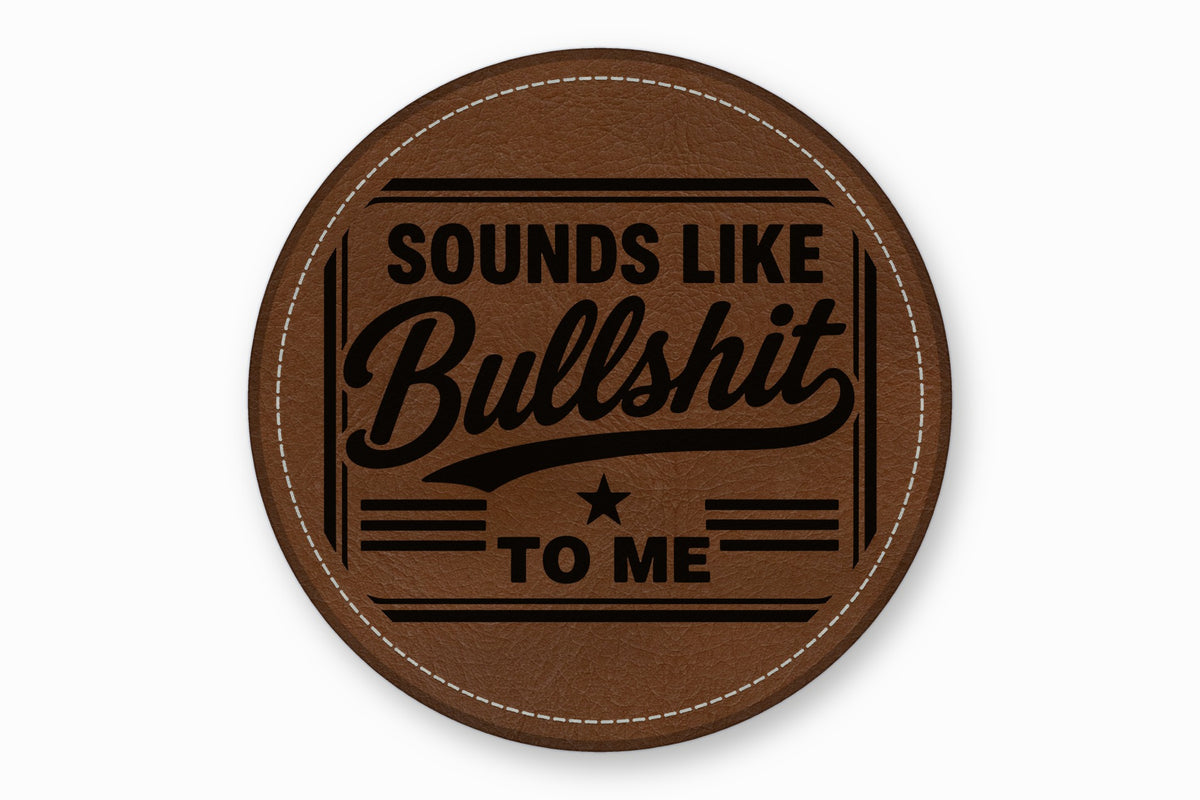 Round brown leather patch with white stitched border and the engraved text Sounds Like Bullshit To Me.