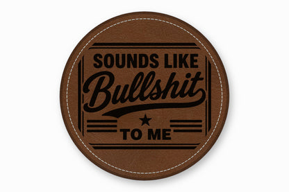 Round brown leather patch with white stitched border and the engraved text Sounds Like Bullshit To Me.