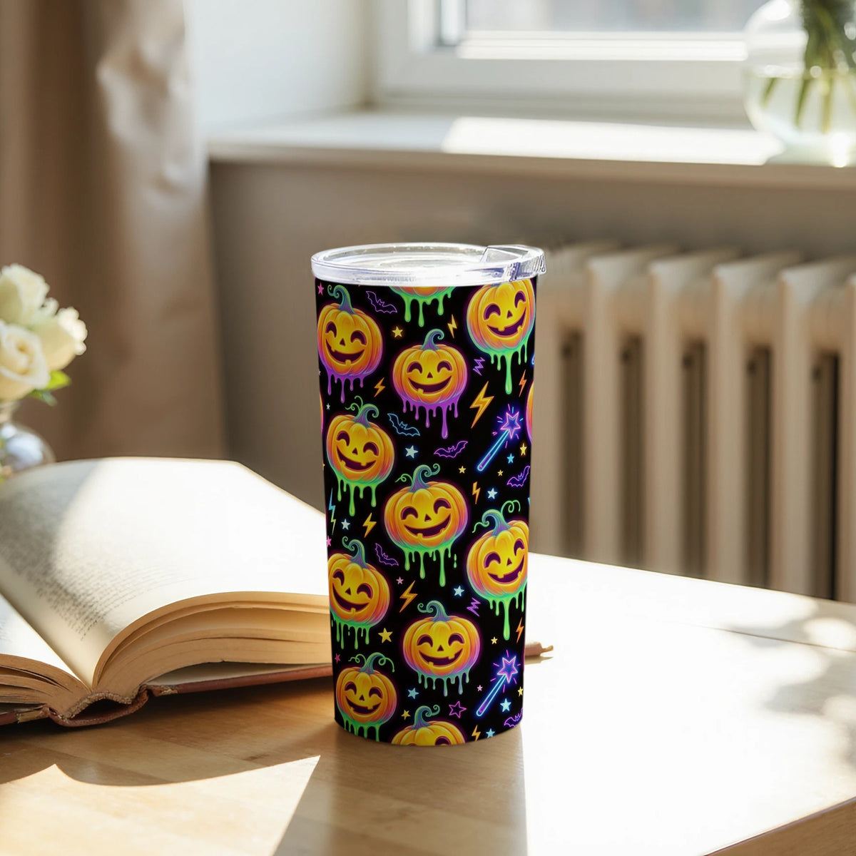 Tumbler with a black background featuring a repeating pattern of smiling jack-o'-lanterns.