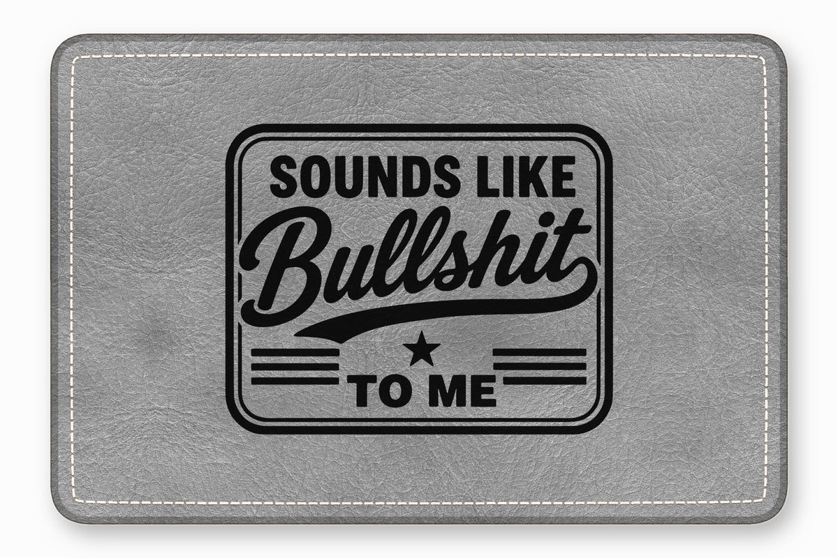 Gray leather mouse pad with white stitching, engraved with the text "SOUNDS LIKE BULLSHIT TO ME".