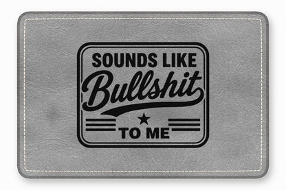 Gray leather mouse pad with white stitching, engraved with the text "SOUNDS LIKE BULLSHIT TO ME".