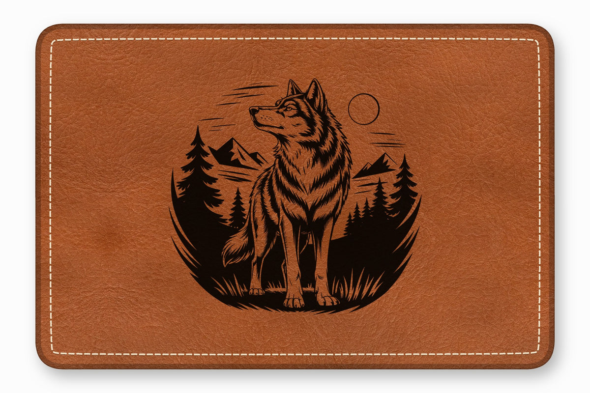 Brown leather patch with rounded corners, white stitching, and a black engraved wolf landscape design.