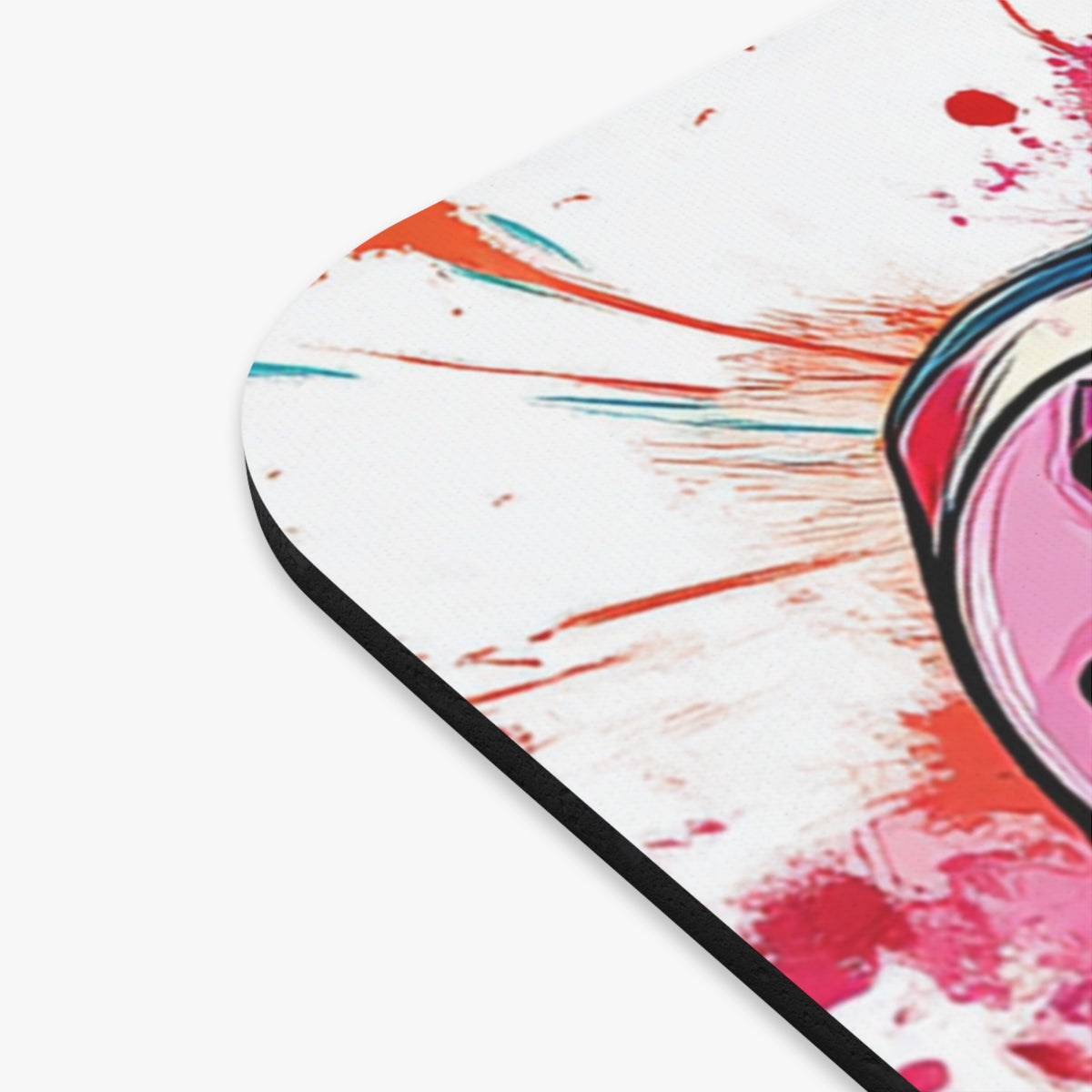 Close-up of a round mousepad with abstract pink, red, and teal paint splatters.