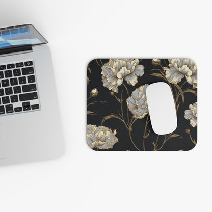 Floral mousepad with white mouse next to a laptop.