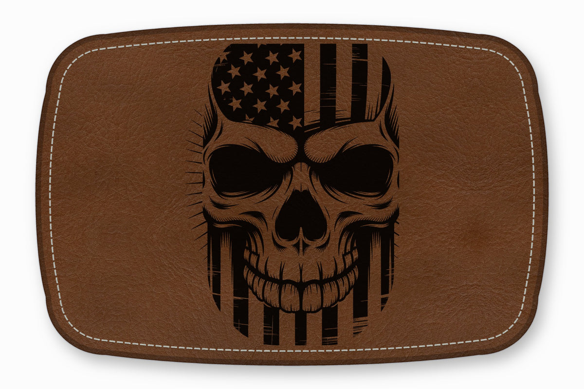 Brown rectangular leather patch featuring a black engraved human skull combined with an American flag.
