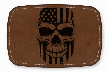 Brown rectangular leather patch featuring a black engraved human skull combined with an American flag.