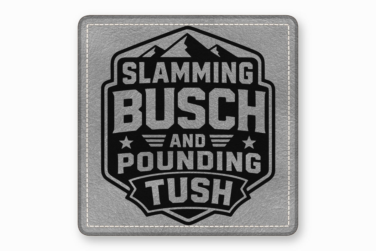 A gray leather patch with white stitched borders and a black mountain emblem containing the text Slamming Busch and Pounding Tush.