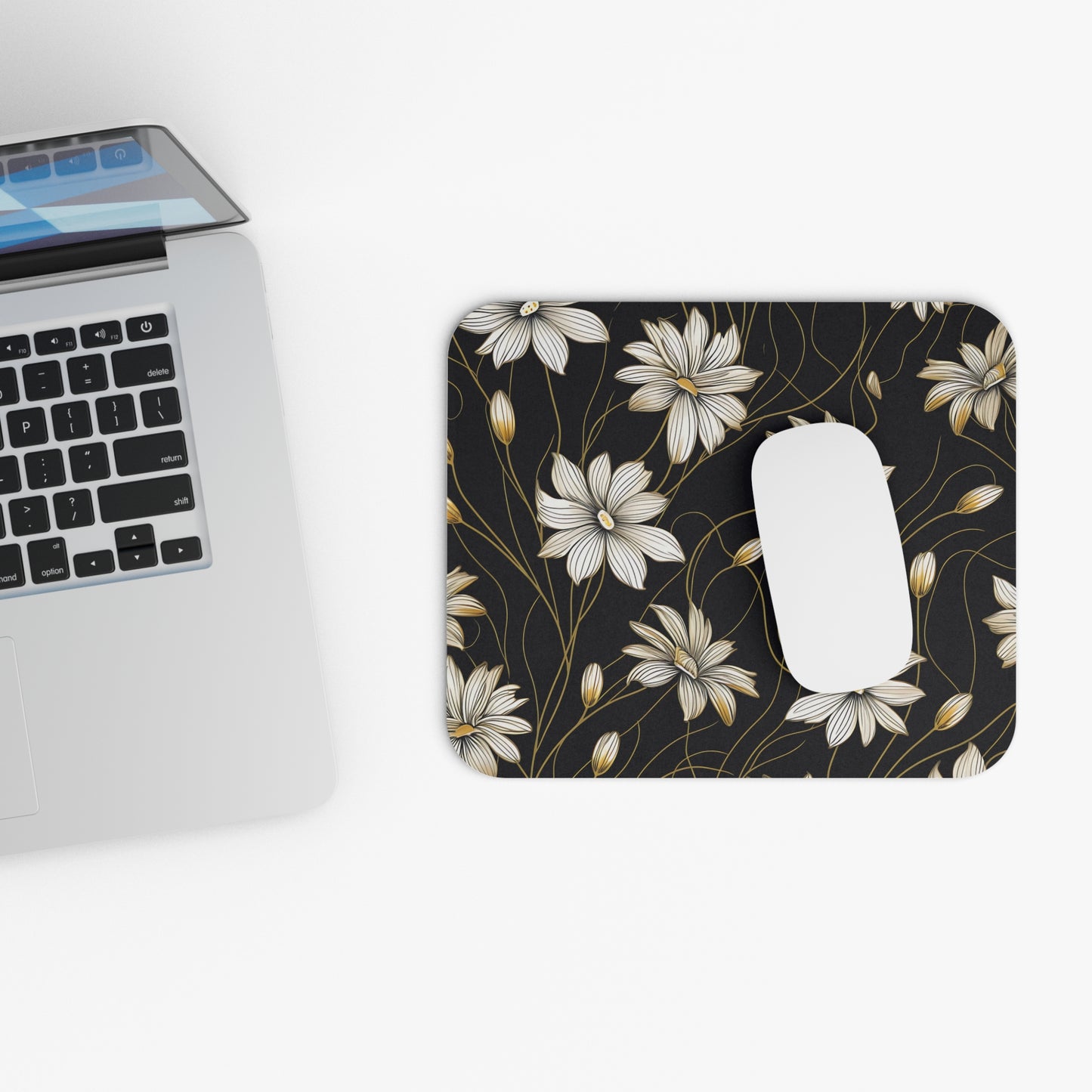 Mousepad with black floral pattern and a white computer mouse.