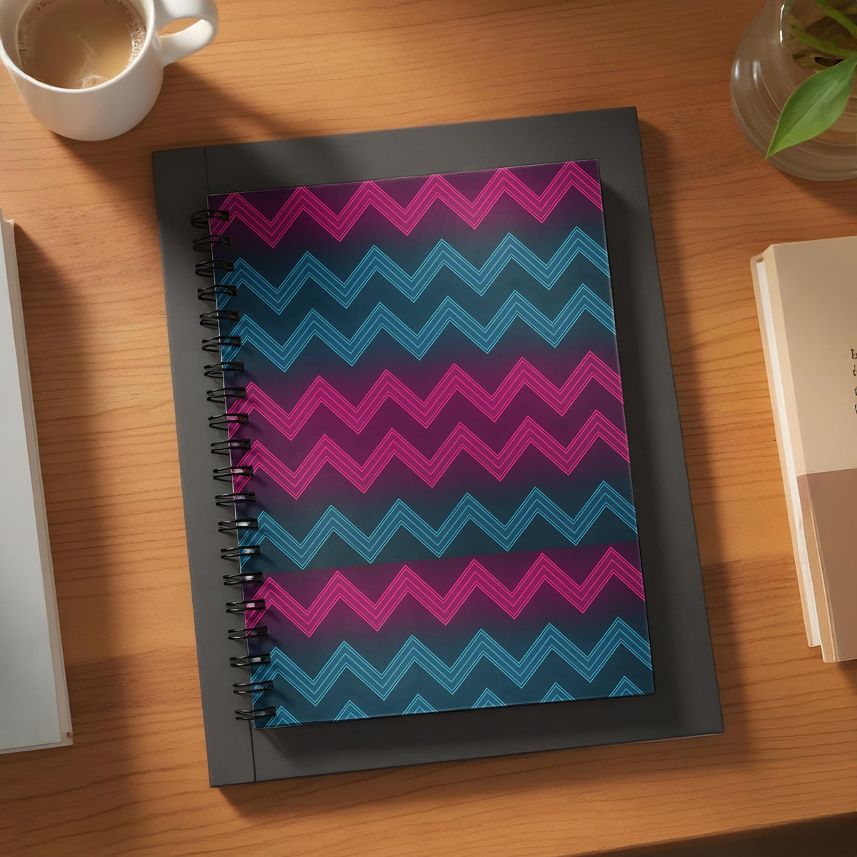Spiral-bound notebook with pink and blue neon zigzag pattern on dark background.