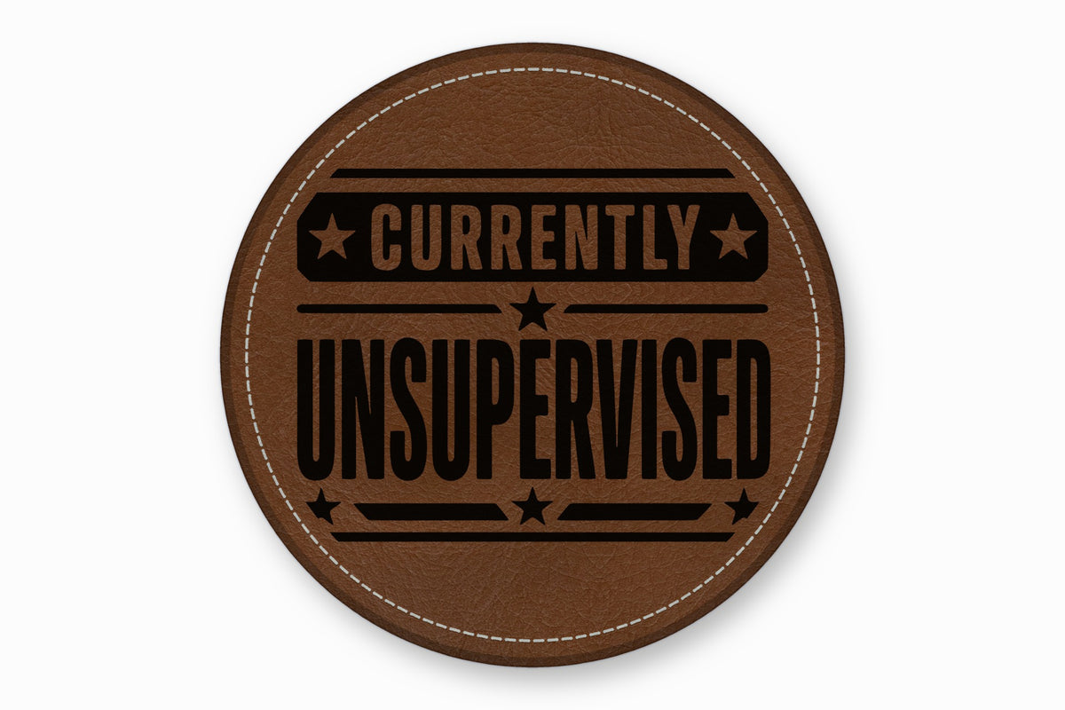 A round brown leather patch with white stitched edges and the text Currently Unsupervised.