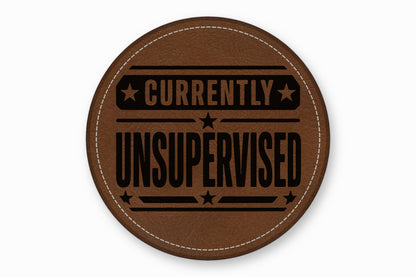 A round brown leather patch with white stitched edges and the text Currently Unsupervised.