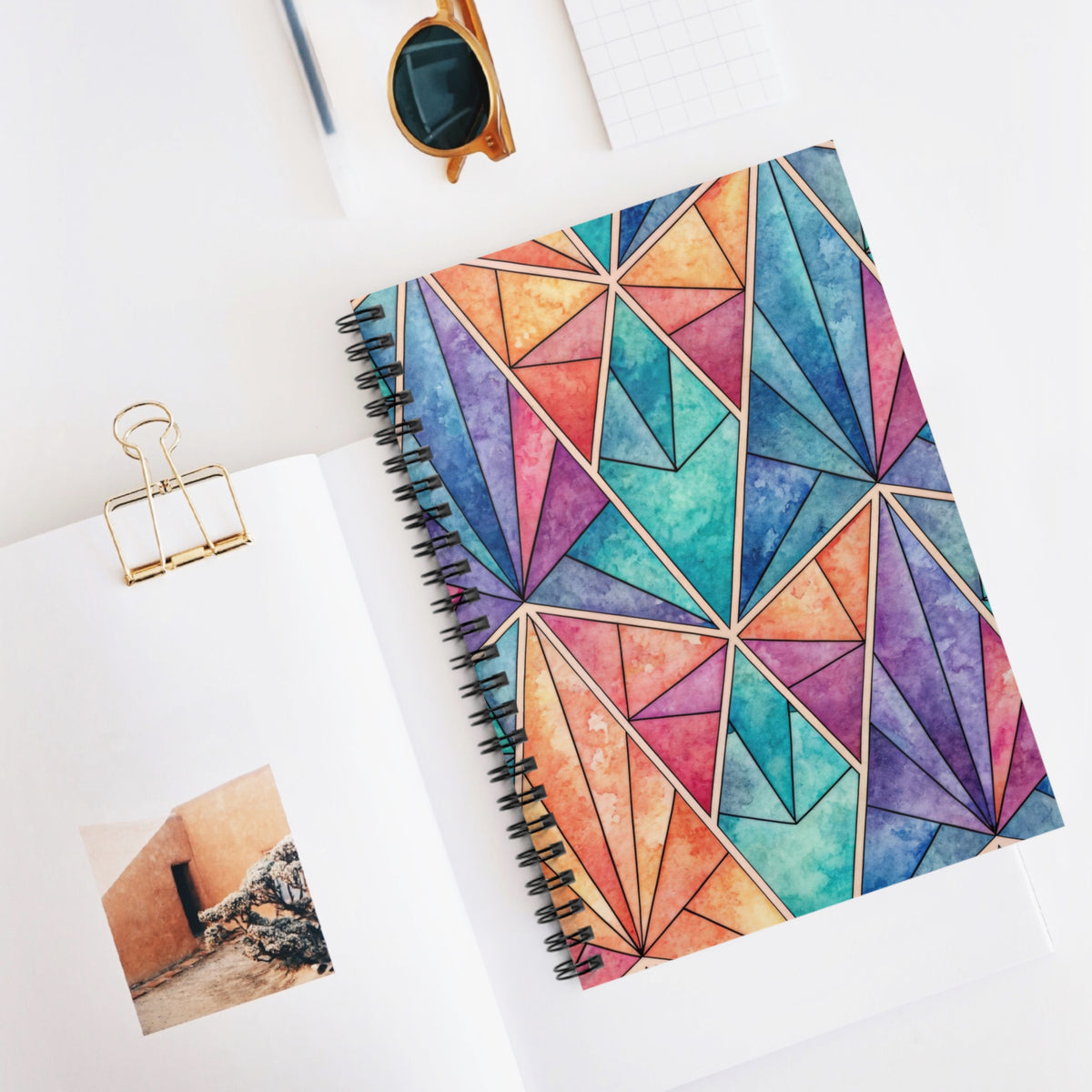Spiral notebook with a colorful geometric watercolor stained glass design.