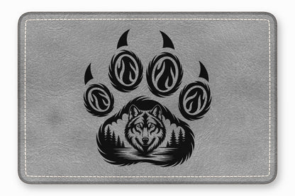 Gray faux leather mousepad featuring a black animal paw print graphic with a wolf and forest design.