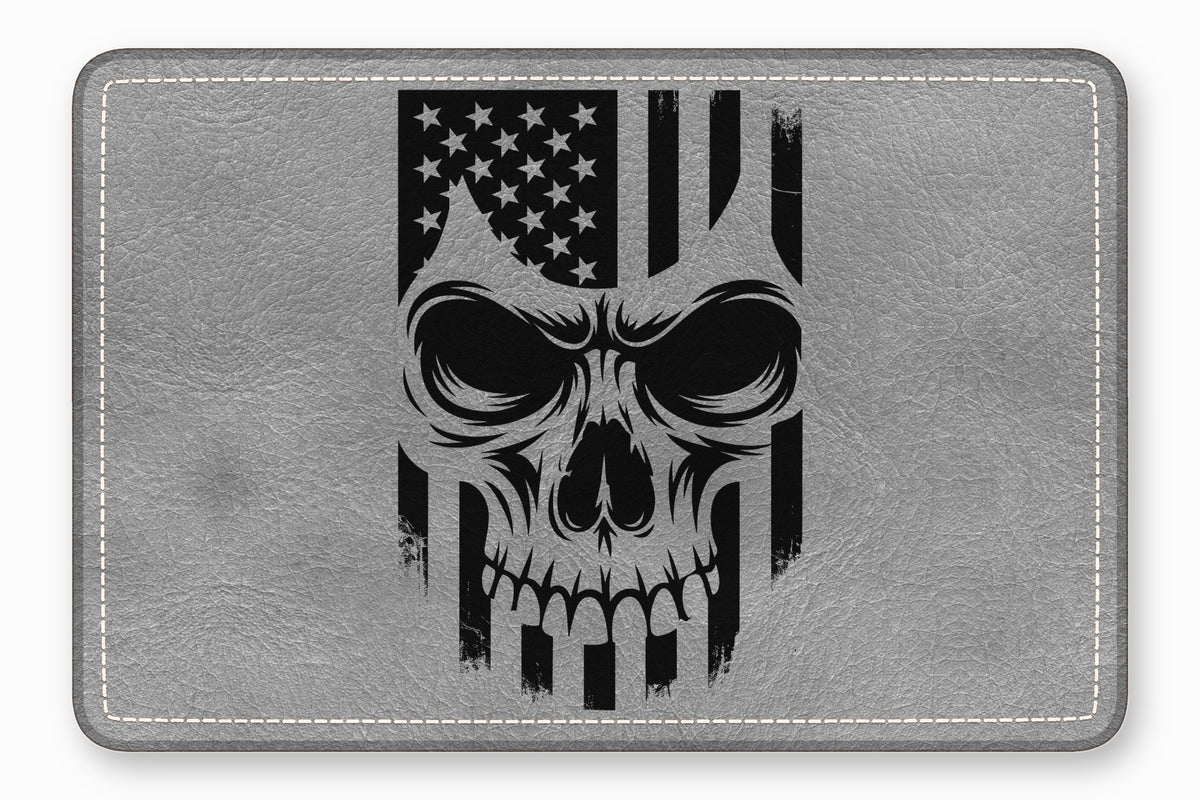 A grey faux-leather rectangular patch featuring a black distressed skull and US flag graphic.