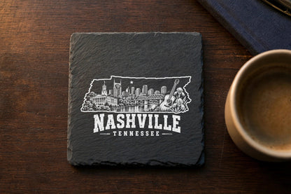 A square slate coaster engraved with a Nashville skyline inside the state of Tennessee outline.